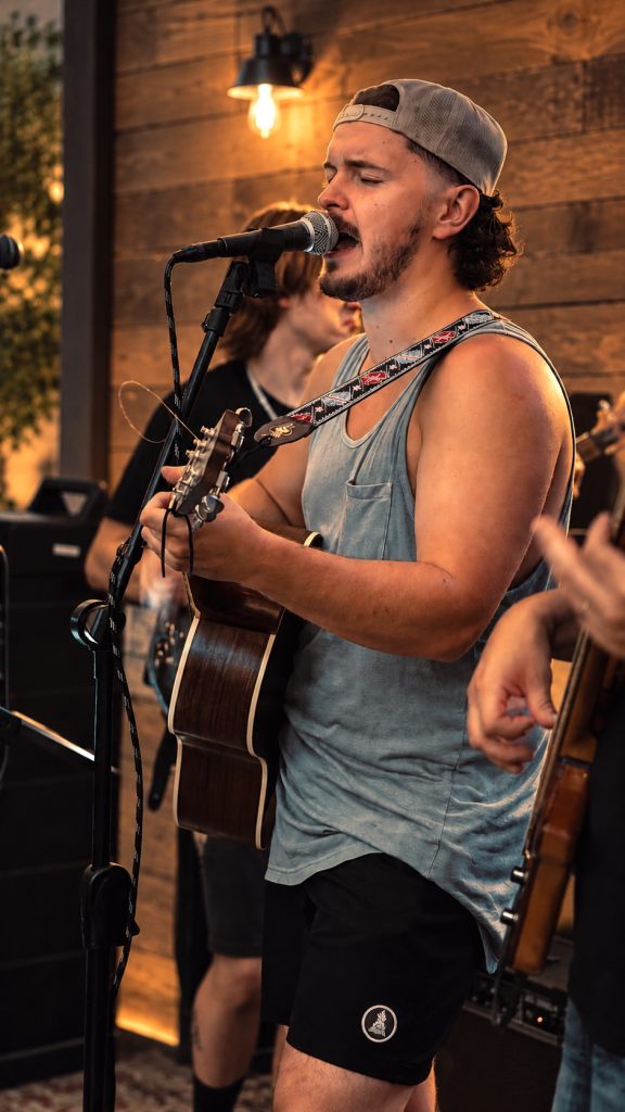 Nic Hitchens playing an acoustic guitar.