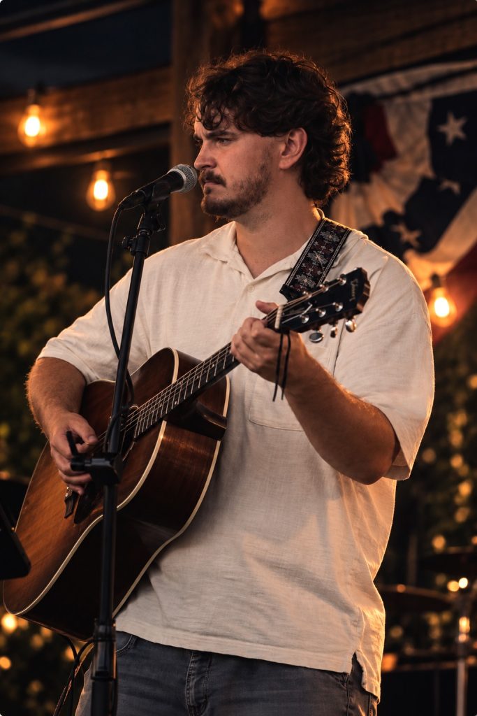 Nic Hitchens playing an acoustic guitar.